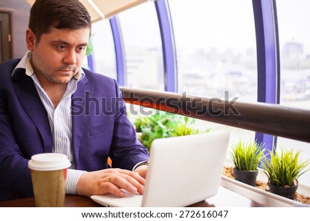 businessman check his email on the computer in a cafe