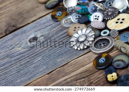 buttons in large numbers scattered on aged wooden boards of old table. Copy space