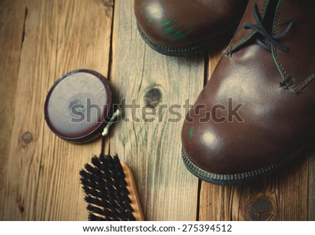 vintage still life with aged brown boots, shoe polish and shoe brush. instagram image retro style