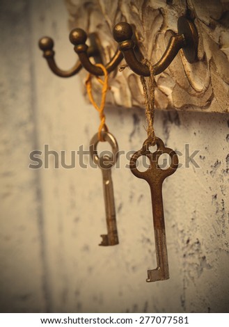 Two vintage keys hanging on hooks. instagram image retro style