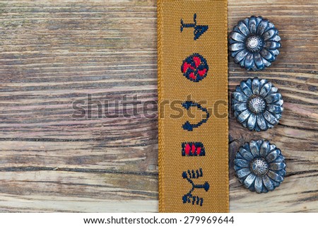vintage buttons andÃ?Â old tape with embroidered ornaments on a textured surface aged boards