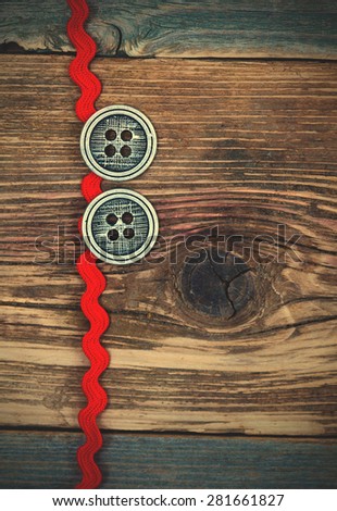 vintage red tape and two old classic buttons on a textured surface aged boards. instagram image filter retro style