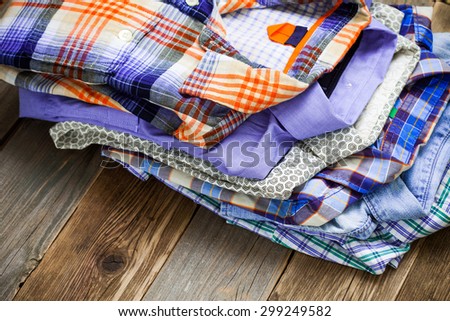stack of colored shirts on a wooden shelf in a store