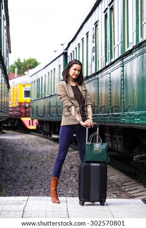 travel in retro style. businesswoman on vacation near vintage passenger wagon on railway station
