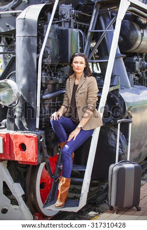 beautiful middle-aged woman going away in the retro-journey on the old steam train