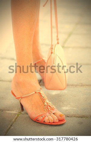 female legs in sandals and hand bag. summer walk. instagram image filter retro style