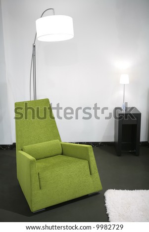 fragment of the interior with green easy-chair and floor-lamp