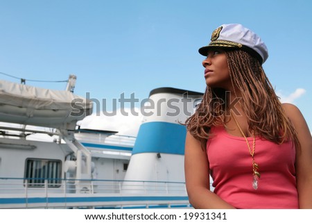 girl in red tanktop and captain service cap on background of the motor ship with copy-space