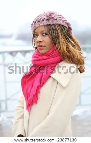 beautiful young woman in warm clothes on the snow background