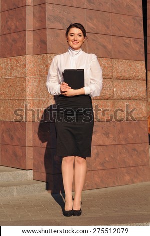 Beautiful businesswoman portrait standing outdoor full body and looking at camera with serious face