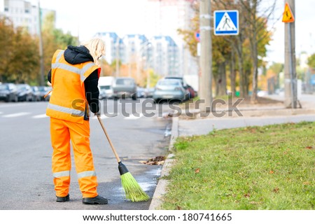 Road sweeper worker cleaning city street with broom tool