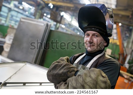 Caucasian industrial welder worker at factory workshop background