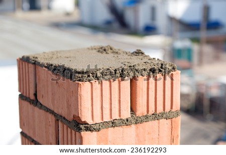 Brick wall building and mortar cement adhesive spreading during construction works