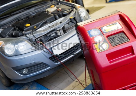 Servicing car air conditioner in vehicle service or repair workshop