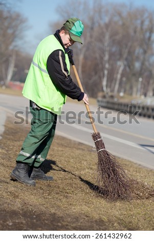 Street Sweeper cleaning walkway in city park with broom tool