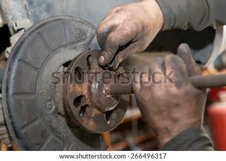 mechanic man worker during car suspension repair works in auto service center