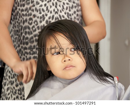 Cute young girl getting a haircut before back to school