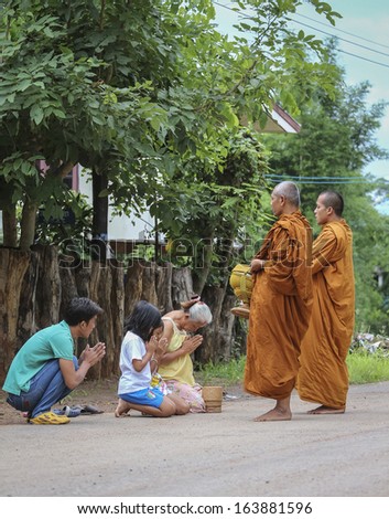 Loei province , Thailand - JULY 18: Every day very early in the morning, the monks walk the streets to beg give food offerings to a Buddhist monk on july 18, 2013 in Loei province , Thailand