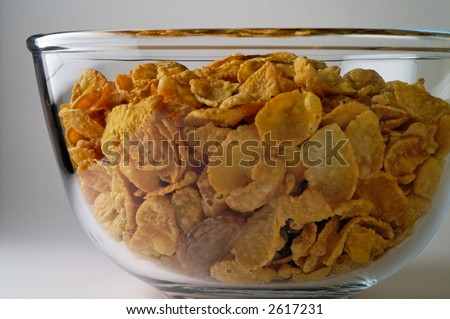 Cereal (corn flakes) and lonely raisin  in glass  bowl (side)
