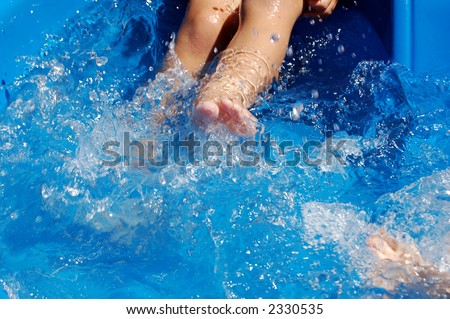 Close-up of boy kicking in kiddie pool.