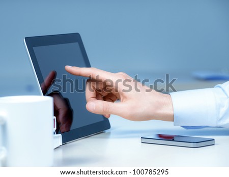 Hand touching on modern digital tablet pc at the workplace.