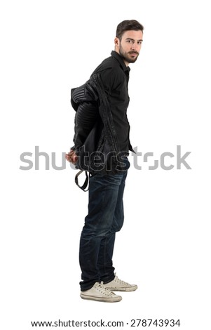 Young bearded handsome male model taking off black leather jacket. Full body length portrait isolated over white background.