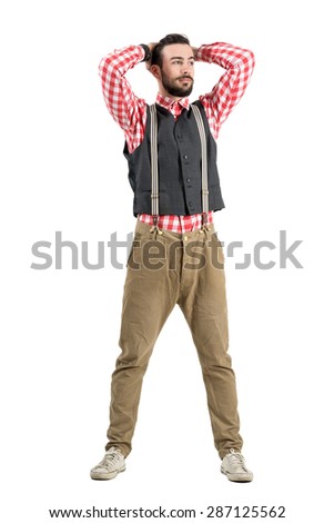 Young hipster adjusting hair with hands looking at distance. Full body length portrait isolated over white studio background.