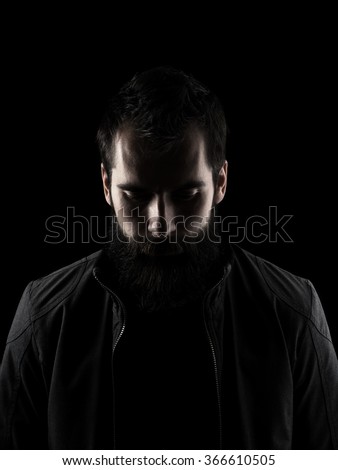 Sad bearded man looking down. Low key dark shadow portrait isolated ...