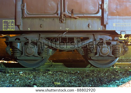 Old cargo train wagon or boxcar wheels on the railway track. Night shot.