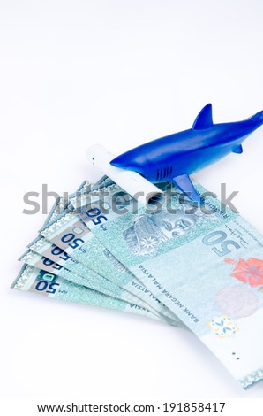 Blue toy shark with money, white isolated