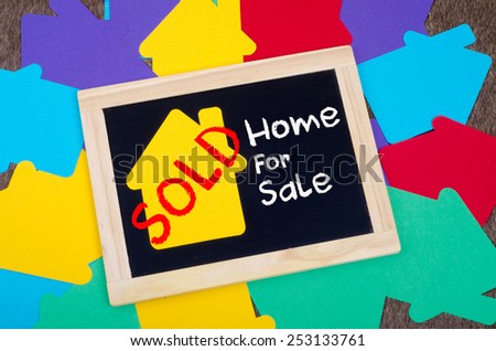 Yellow home sign on the blackboard: Real Estate Concept, Home for sale SOLD