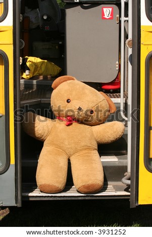 Teddy bear sitting in doorway of old bus