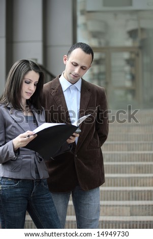 client reading contract next to a business man in the city