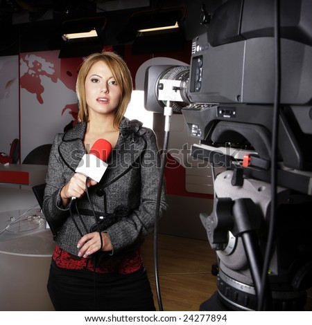 sensual journalist on the air transmitting news reports on television in front of the video camera