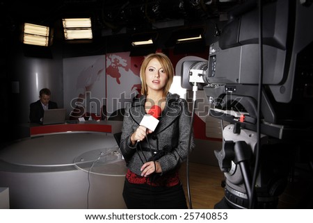 attractive television news presenter standing in front of the video camera