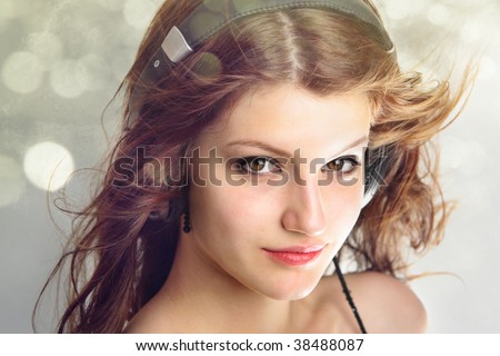 Confident gorgeous teen age girl listening to music showing a lot of pleasure on her face  isolated on bokeh background