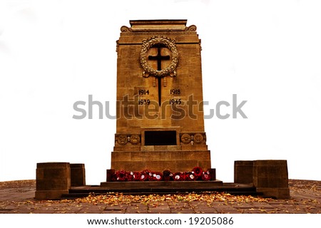 Isolated war memorial monument with poppies laid around it.