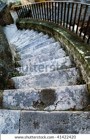 Steep grungy old stone steps belonging to a small ancient castle.