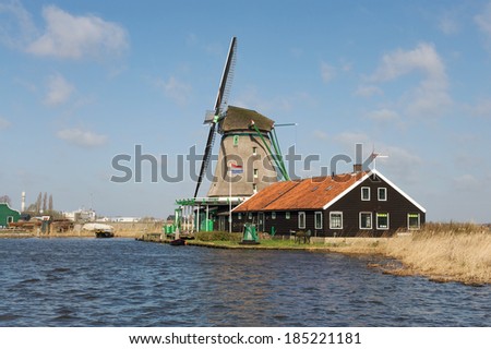 Traditional Dutch windmill near the river on a sunny day, the Netherlands