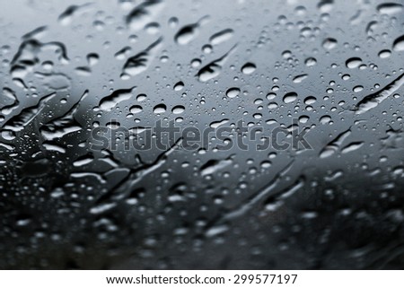 Rain droplets on windshield. This is a close up shot of rain droplets so only very little section meant to be in focus to create a gloomy mood.