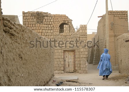 A Tuareg nomad of the Berber people wanders the muddy  back streets of Timbuktu, Mali