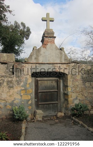 This gate entrance to the mission cemetery of Santa Barbara California is hand made from rock and adobe