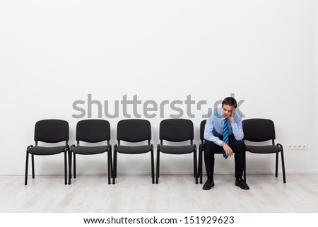 Desperate businessman or employee sitting alone propping his head