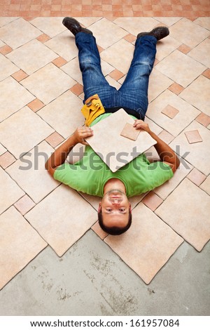Man resting on ceramic floor tiles - taking a short break