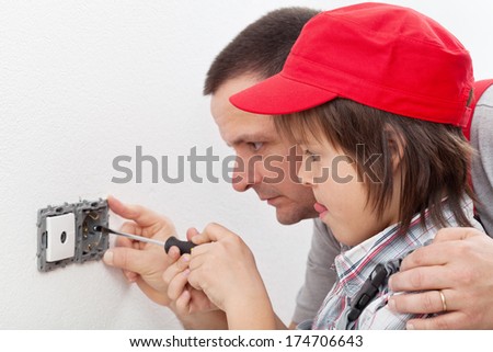 Doing things around the house - boy and his father changing an electrical wall fixture