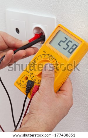 Electrician hands installing electrical wall sockets - closeup, focus on the fixture