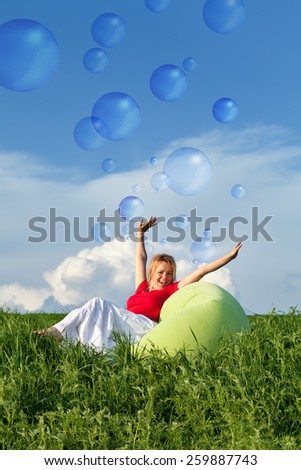 Bubbling vitality - woman on spring grassland enjoying sunshine