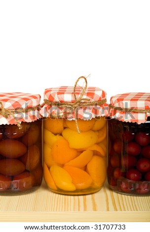 Homemade canned fruits in jars on the shelf - isolated