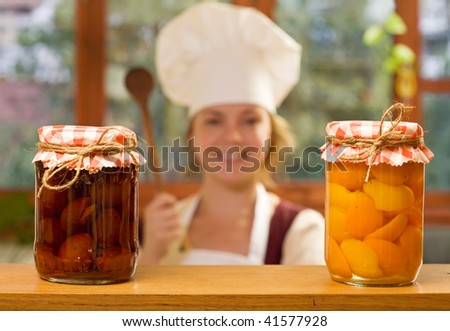 Proud woman chef with homemade canned fruit