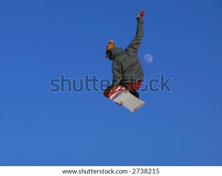 A snowboarder going big high above the half pipe